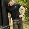 Kurze Lederhose mit schlichtem T-Shirt kombiniert