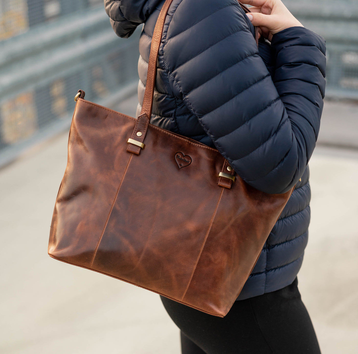 Frau trägt braune Hodalump Schultertasche aus Leder im eleganten Vintage Stil.