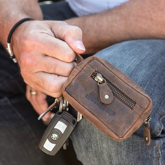 Mann hält braunes Hodalump Schlüsseletui aus Leder mit Autoschlüssel in der Hand.