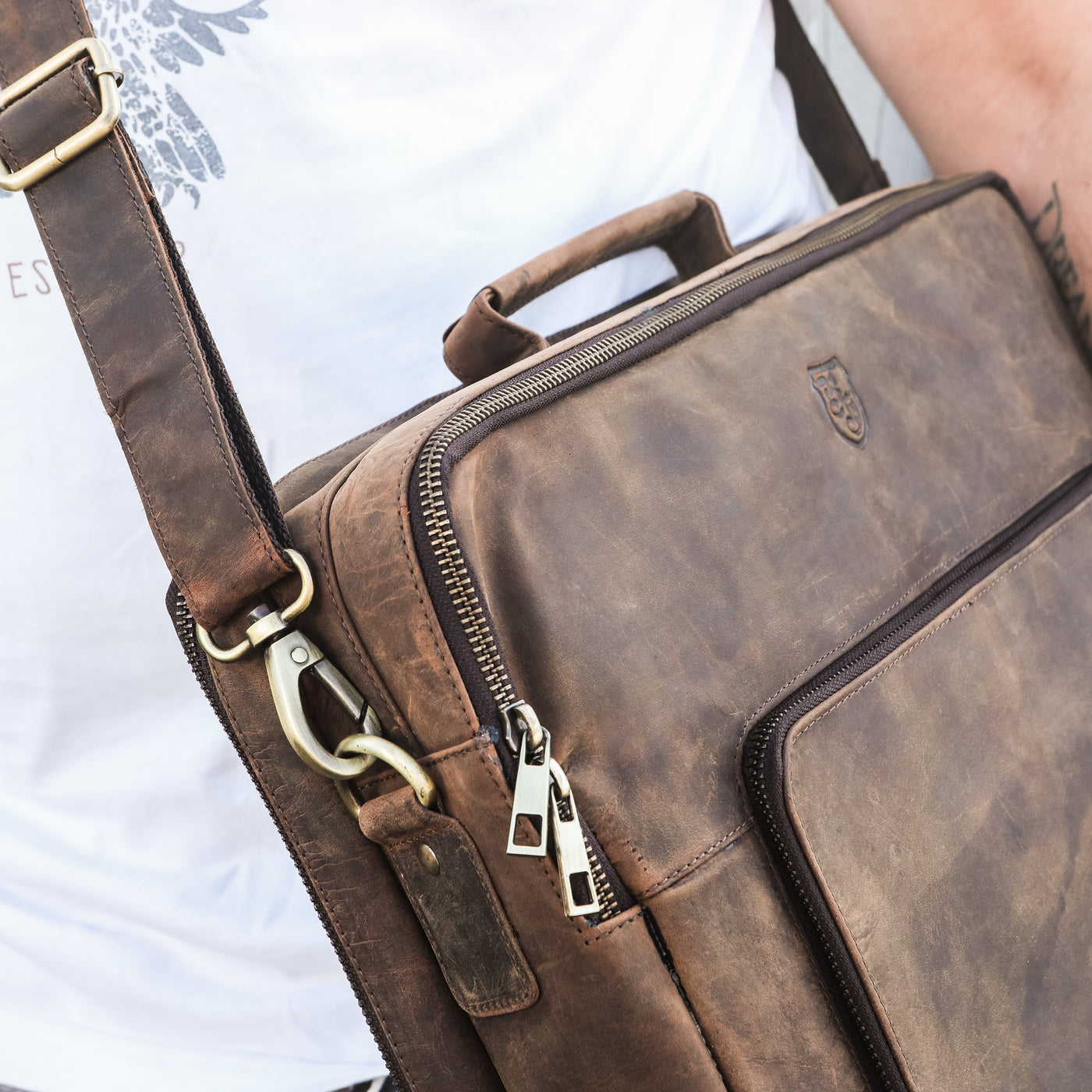 Braune Hodalump Laptoptasche aus Leder mit Schulterriemen und Reißverschluss.