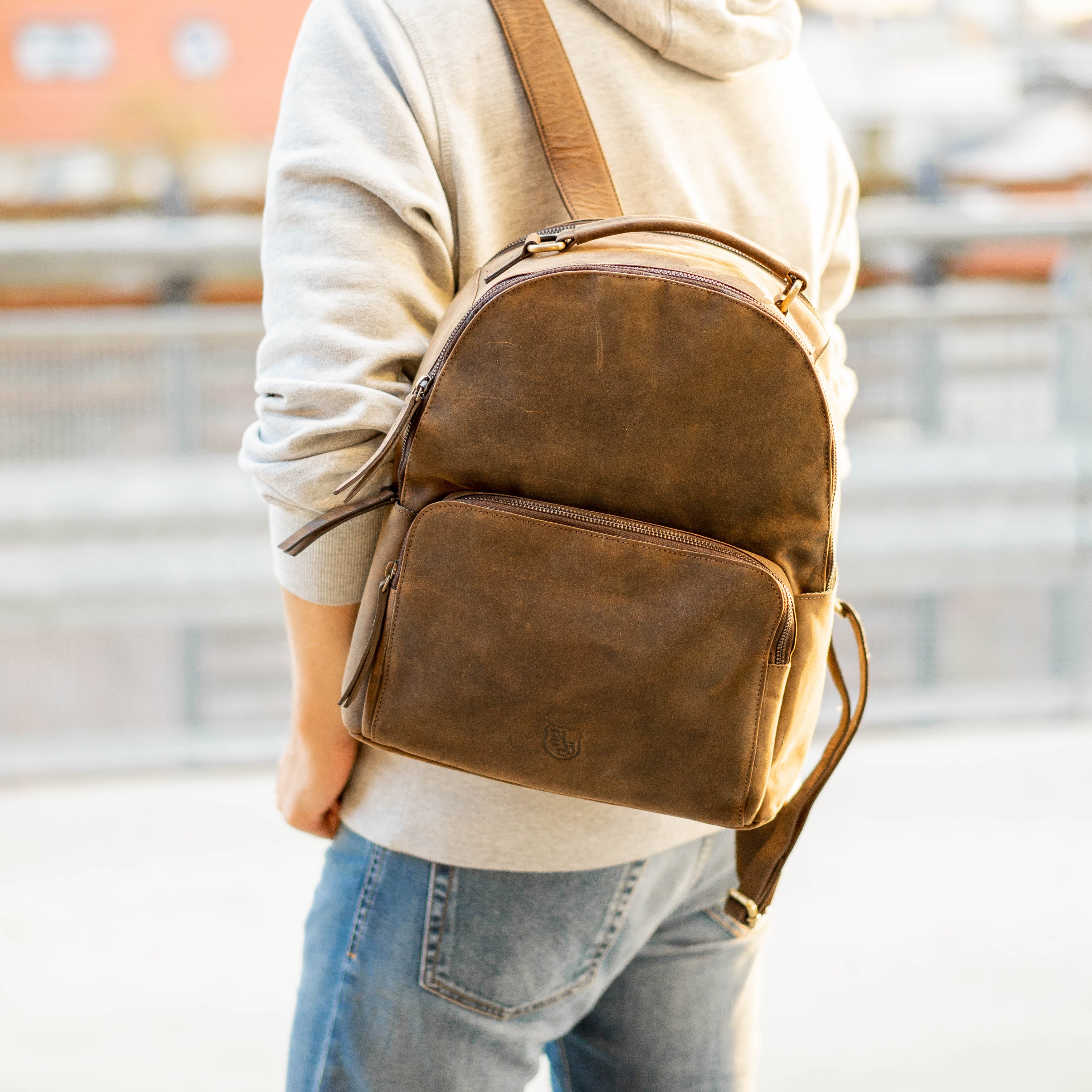 Person trägt braunen Hodalump Rucksack aus Leder im modernen Vintage Stil.