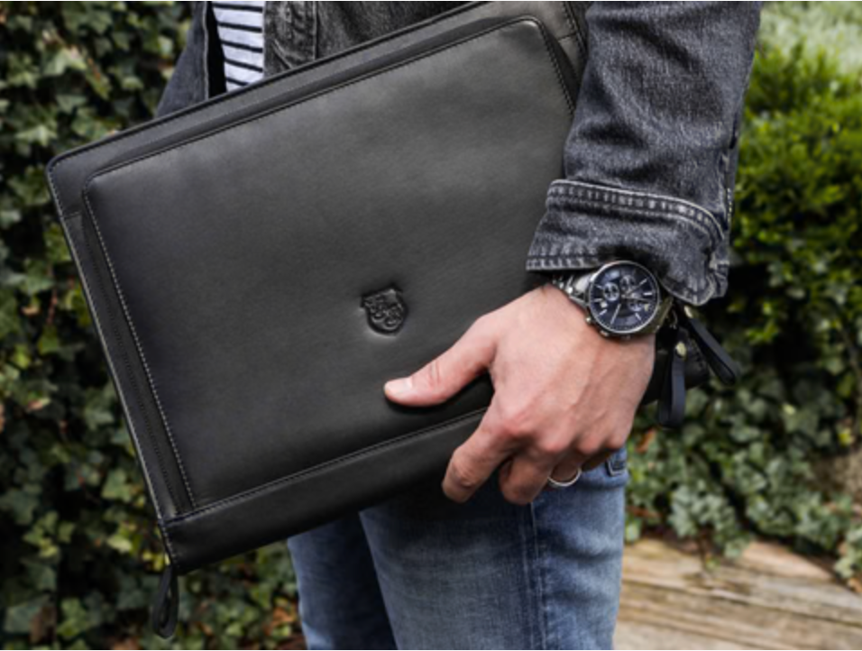 Mann trägt schwarze Hodalump Laptoptasche aus Leder im modernen Business Stil.